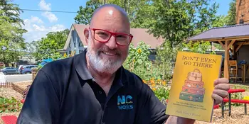 Mark Bloom holding his book